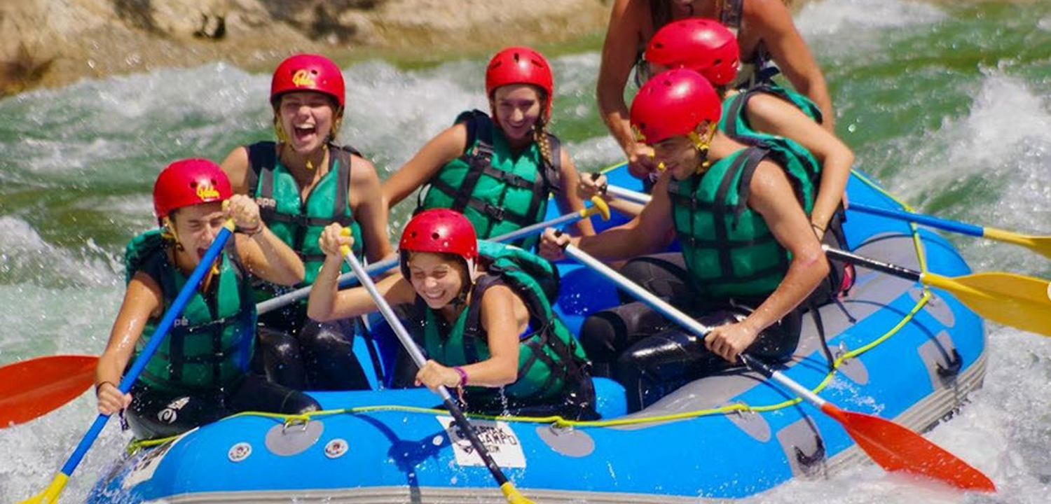 Imagen de varios chicos en una balsa haciendo rafting